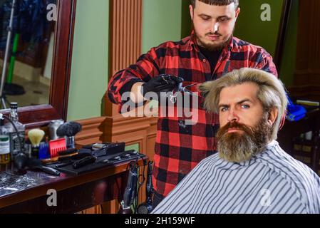 Zuversichtlich in seiner Wahl. Hipster mit gefärbtem Bart und Schnurrbart. Mann wollen neue Frisur. Männliche Schönheit und Mode. Reifer Mann im Friseurladen. Brutal Stockfoto