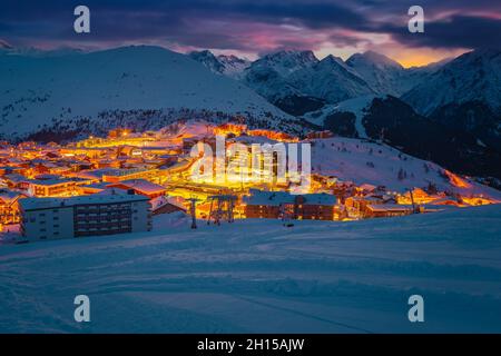 Tolles Winterskigebiet und Stadtbild am Abend nach Sonnenuntergang. Eines der schönsten Winterreiseziele, Alpe d Huez, Rhone Alps, Frankreich, E Stockfoto