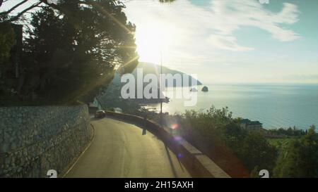 Erstaunliche Luftaufnahme der schönen mediterranen Landschaft mit kurvigen Bergstraße in der Küstenstadt bei Sonnenaufgang. Aufnahme. City Bay und Mountain Stockfoto