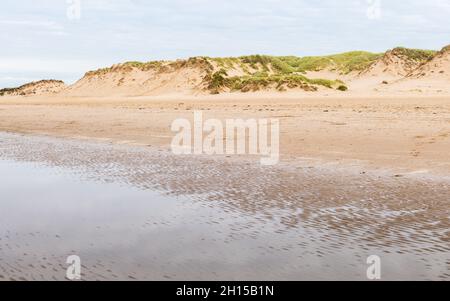 Wellen in einem Wasserbecken, das bei Ebbe am Strand von Formby in der Nähe von Liverpool hinterlassen wurde. Stockfoto