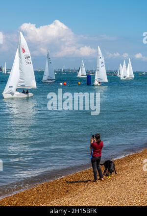 Junge Frau mit Hund am Strand auf der Insel wight bei der cowes Week Segelregatta. isle of wight, cowes, Segeln, Hundespaziergänger, junge Hündin am Strand. Stockfoto