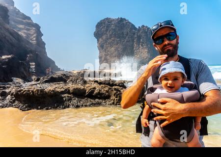 Junger Vater und sein Baby in Roque del Moro, Cofete Strand, Jandia Naturpark, Barlovento, Spanien Stockfoto