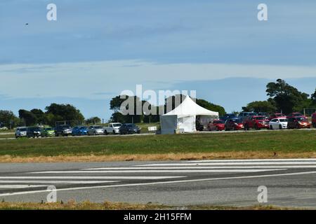 GREYMOUTH, NEUSEELAND, 16. OKTOBER 2021:Hitzedunst verdunkelt teilweise das Bild von Menschen in Greymouth, die am Super-Samstag wegen der Massenimpfung von Covid am Flughafen Schlange standen. 130,000 wurden landesweit geimpft. Stockfoto
