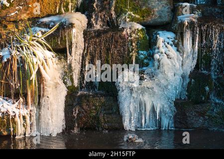 Kleiner eingelassener Wasserfall am Schloß Favorit im Winter Stockfoto