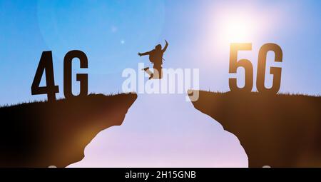 Technologiewechsel von 4G LTE zu 5G, einem globalen Mobilfunknetz. Silhouette Mann springt von Klippe zu Klippe auf Himmel Hintergrund. Modernes Netzwerkkonzept Stockfoto