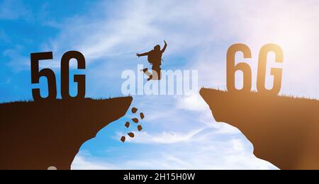 Die Technologie ändert sich von 5G zu 6G, einem globalen Mobilfunknetz. Silhouette Mann springt von Klippe zu Klippe auf Himmel Hintergrund. Modernes Netzwerkkonzept Stockfoto
