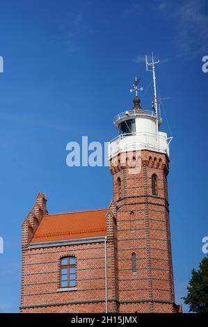 USTKA, POLEN - 06. Aug 2013: Das alte neugotische Leuchtturmgebäude an einem sonnigen Tag in Ustka, Polen Stockfoto