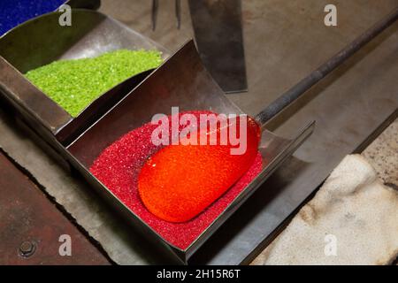 Hinzufügen von farbiger Fritte zu heißem Glas an der Glass Academy in Dearborn, Michigan Stockfoto