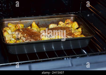 Zwei gebackene Schweinesteaks mit Kartoffeln. Fleisch mit Kartoffeln im Ofen. Hausgemachte Speisen. Schweinefleischeintopf mit Kartoffeln Stockfoto