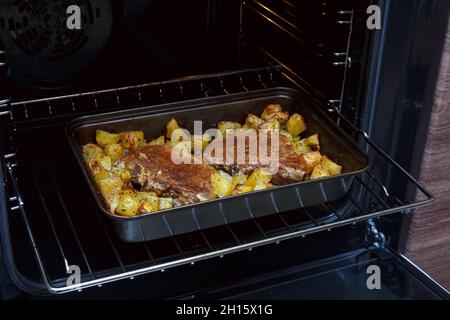 Zwei gebackene Schweinesteaks mit Kartoffeln. Fleisch mit Kartoffeln im Ofen. Hausgemachte Speisen. Schweinefleischeintopf mit Kartoffeln Stockfoto