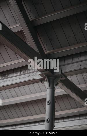 Vertikale Graustufenaufnahme der hölzernen Verkleidung innen des Daches Stockfoto