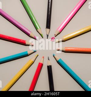 Buntstifte Draufsicht Kreislayout auf grauem Hintergrund. Zerstoßener rosa Bleistift. Minimales Schul- und Bildungskonzept. Stockfoto