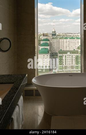 Badezimmer mit Badewanne, Blick auf die Stadt im Ritz Carlton Astana, Kasachstan Stockfoto