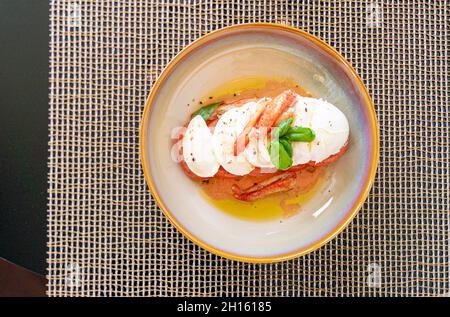 Caprese, traditioneller italienischer Salat, mit Garnelen, frisch geschnittenem Mozzarella und süßem Basilikum; Olivenöl. Serviert im Mokki Restaurant; Astana Stockfoto