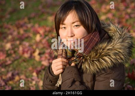 Eine junge Frau sitzt in einem Park MR - Model freigelassen Stockfoto