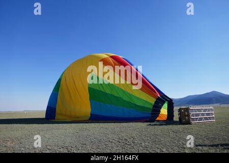 Luftballon in Regenbogenfarben, der seitlich aufliegt Stockfoto