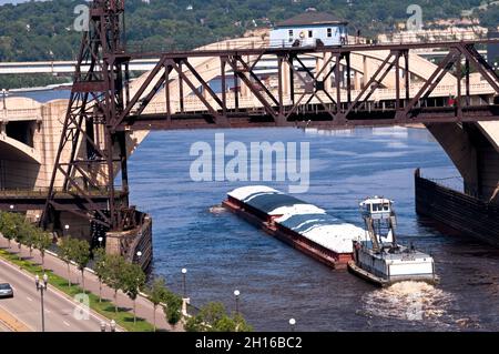 Eine große Barge fährt unter der Lift Bridge auf dem Mississippi River in der Innenstadt von St. Paul, Minnesota. Stockfoto