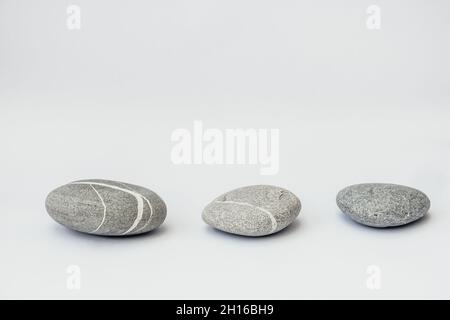 Steine sind auf dem hellen Hintergrund, einfache Gelassenheit Steine. Reinheit Harmonie und Balance Konzept. Steinpodien. Stockfoto