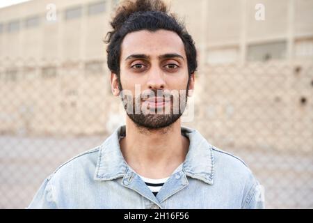 Porträt eines ernsthaften muslimischen jungen Mannes, der die Kamera anschaut. Stockfoto