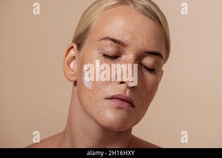 Nahaufnahme Porträt der schönen kaukasischen Frau mit Anti-Aging-Creme auf dem Gesicht Stockfoto