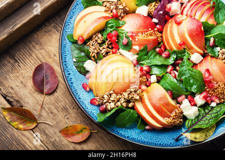Diätsalat aus Äpfeln, Käse, Rucola und Haferflocken. Gesunder Salat auf rustikalem Holztisch Stockfoto