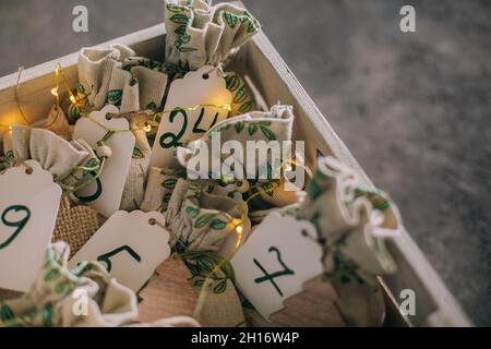 Kreativer weihnachts-Adventskalender für Kinder. Geschenke für Kinder Spaß in Stofftaschen in Holzkiste. Stockfoto