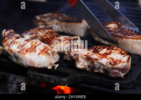 BBQ Grill Pit mit Glowing and Flaming Hot, Steaks, Food Background, Close-Up. Selektiver Fokus. Stockfoto