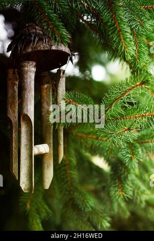 Windspiele hängen in einem Weihnachtsbaum. Bambusgimus im Garten. Stockfoto