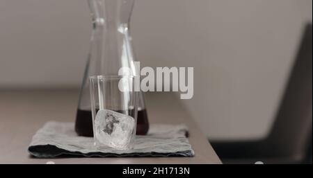 Eiswürfel aus Glas auf Walnusstisch, breites Foto Stockfoto