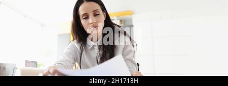 Frau sitzt an der Rezeption halten Dokument lesen Brief fühlt sich enttäuscht über schlechte Nachrichten schockiert Stockfoto