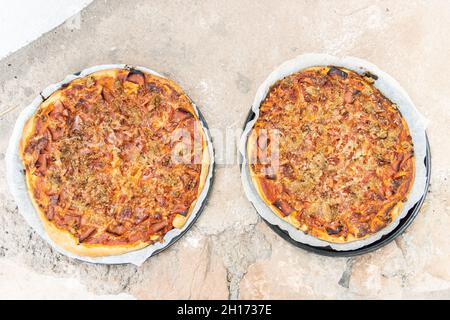Pizza aus einem weiß lackierten, handgefertigten Holzofen, der auf der Außenseite gebaut wurde Stockfoto