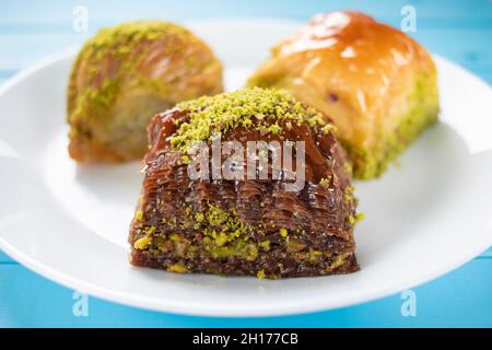 Traditionelles türkisches Gebäck Dessert Baklava. Drei verschiedene Arten von Baklava Schokolade, pistaccio und trocken. Schokoladengebäck mit pistaccio im Fokus. Stockfoto