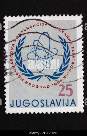 JUGOSLAWIEN - CA. 1961: Ein in Jugoslawien gedruckter Stempel zeigt das Emblem der Internationalen Atomkommission, die Internationale Nuklearelektronikkonferenz Stockfoto