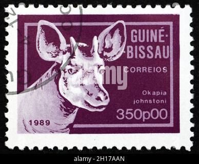 GUINEA-BISSAU - CIRCA 1989: Ein in Guinea-Bissau gedruckter Stempel zeigt Okapi, okapia johnstoni, auch bekannt als Waldgiraffe oder Zebragiraffe, circa 1989 Stockfoto