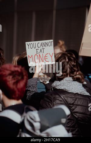 Schild: „man kann Geld nicht essen“. Am 15.10.2021 fand in München, wie jeden Freitag, ein von FreitagsForFuture organisierter Klimaveranstaltung statt, auf dem lautstark mit über 130 Teilnehmern*innen für die Inhalation des 1, 5 Grad Ziels demontiert wurde. * Zeichen: „Sie können kein Geld essen“. Am 8. Oktober 2021 nahmen mehr als 130 Menschen an einer Demonstration für Klimagerechtigkeit und das 1.5-Grad-Ziel in München Teil. (Foto von Alexander Pohl/Sipa USA) Stockfoto