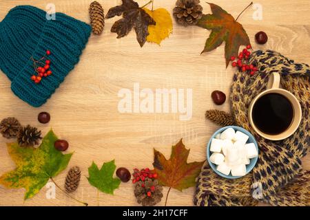 Herbstkomposition mit Hut, Blättern und Moorschellen. Von oben auf einem hölzernen Hintergrund aufgenommen. Stockfoto