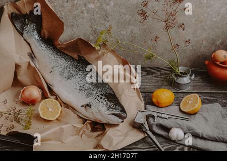 Stillleben mit Fisch und Gemüse auf einem Küchentisch aus Holz Stockfoto