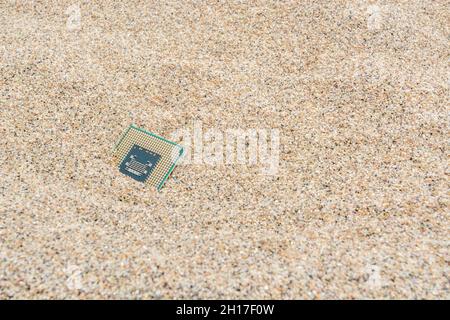 Uralte Computer-CPUs, die in einem Sandhaufen für Computer-Friedhof, Legacy-Computing begraben sind. Intel Mobile Computing Merom cpu vorhanden. Stockfoto