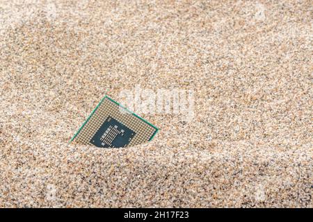 Uralte Computer-CPUs, die in einem Sandhaufen für Computer-Friedhof, Legacy-Computing begraben sind. Intel Mobile Computing Merom cpu vorhanden. Stockfoto