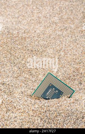 Uralte Computer-CPUs, die in einem Sandhaufen für Computer-Friedhof, Legacy-Computing begraben sind. Intel Mobile Computing Merom cpu vorhanden. Stockfoto