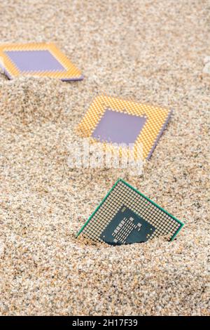 Uralte Computer-CPUs, die in einem Sandhaufen für Computer-Friedhof, Legacy-Computing begraben sind. Intel Mobile Computing Merom, AMD Duron und K6 cpu. Stockfoto