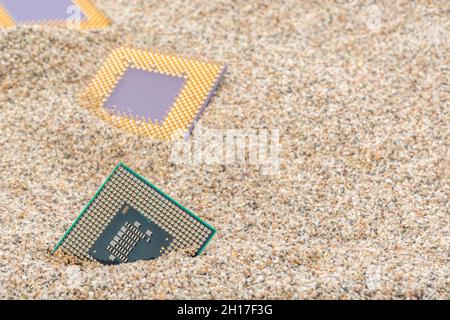 Uralte Computer-CPUs, die in einem Sandhaufen für Computer-Friedhof, Legacy-Computing begraben sind. Intel Mobile Computing Merom, AMD Duron und K6 cpu. Stockfoto