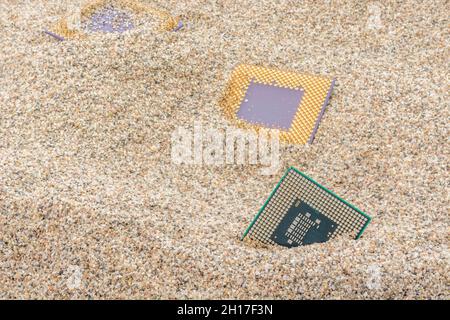 Uralte Computer-CPUs, die in einem Sandhaufen für Computer-Friedhof, Legacy-Computing begraben sind. Intel Mobile Computing Merom, AMD Duron und K6 cpu. Stockfoto