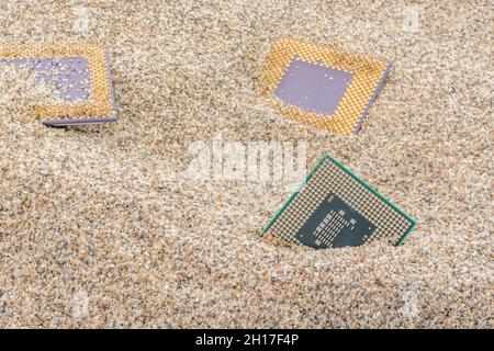 Uralte Computer-CPUs, die in einem Sandhaufen für Computer-Friedhof, Legacy-Computing begraben sind. Intel Mobile Computing Merom, AMD Duron und K6 cpu. Stockfoto