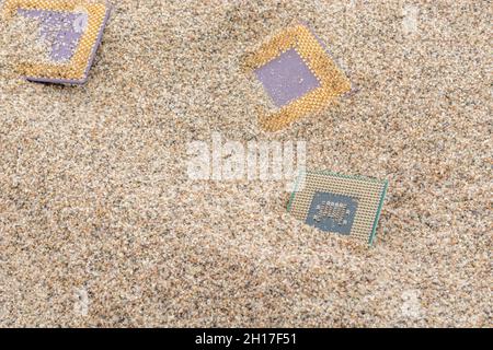 Uralte Computer-CPUs, die in einem Sandhaufen für Computer-Friedhof, Legacy-Computing begraben sind. Intel Mobile Computing Merom, AMD Duron und K6 cpu. Stockfoto