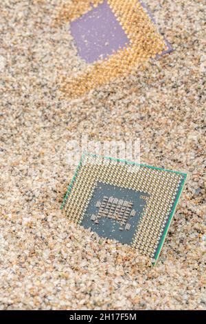 Uralte Computer-CPUs, die in einem Sandhaufen für Computer-Friedhof, Legacy-Computing begraben sind. Intel Mobile Computing Merom und AMD Duron cpu präsentieren. Stockfoto