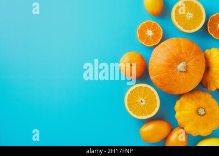 Gelbe und orange Früchte und Gemüse auf blauem Hintergrund, Herbstkonzept, Kopierraum Stockfoto