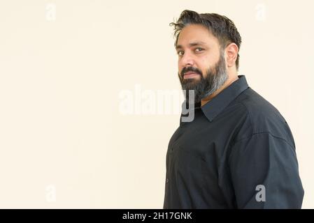 Porträt eines gutaussehenden indischen Mannes vor einfachem Hintergrund Stockfoto