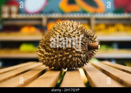 Nahaufnahme der Vorderansicht von frischem, saftigem Litschi, der auf einer Holzpalette im Obst- und Gemüsebereich des Lebensmittelladens steht. Stockfoto