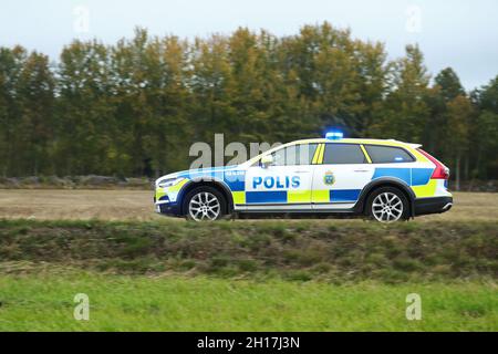 Polizeiauto auf dem Weg zu einem Verkehrsunfall auf Evertsbyvägen, Motala, Schweden, als ein LKW aus unbekannten Gründen zwei Container auf der Straße verlor, in die ein Auto dann einfuhr. Polizei, Rettungsdienst und Krankenwagen vor Ort. Stockfoto